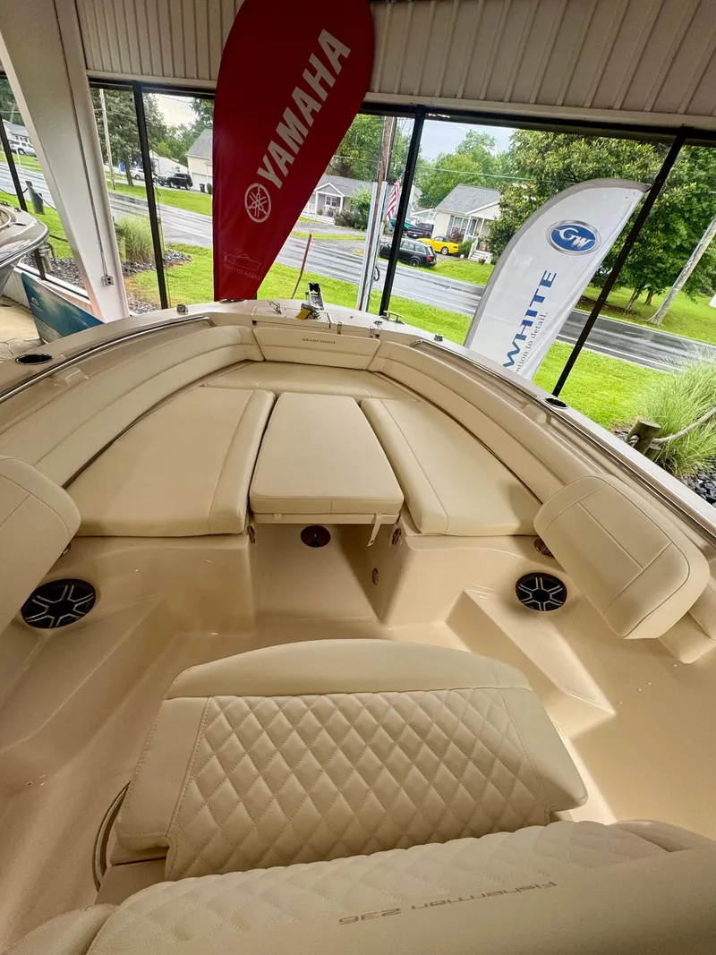 Slide: The Image of 2025 Grady-White Fisherman 236 boat interior with beige seating and Yamaha banner. - 8