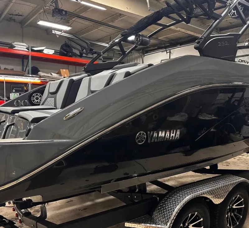 Slide: The Image of 2025 Yamaha Boats 222XD in a showroom, sleek black design on a trailer. - 8