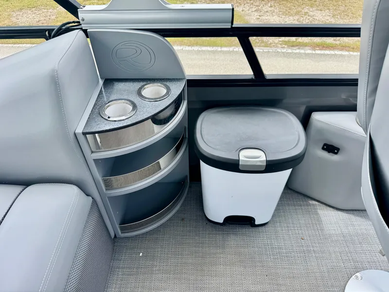 Slide: The Image of Interior of 2022 Regency 230 LE3 boat with cup holders and storage bin. - 24