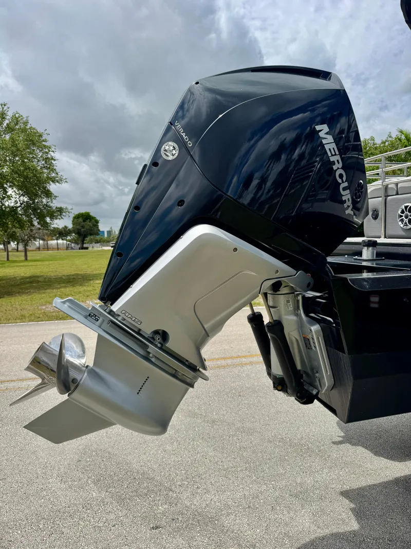 Slide: The Image of 2022 Regency 230 LE3 boat with Mercury outboard motor, parked outdoors. - 27