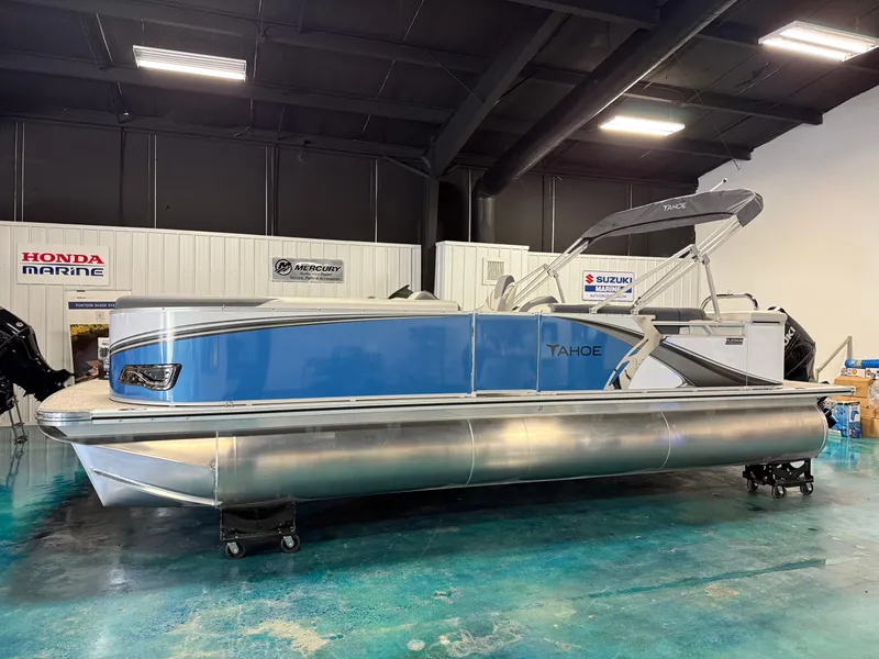 Slide: The Image of 2025 Tahoe Pontoon LTZ Cruise in showroom, featuring sleek blue design and modern amenities. - 2