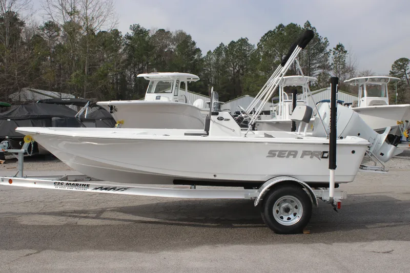 Slide: The Image of 2025 Sea Pro 172 boat on trailer, parked outdoors with trees in background. - 2