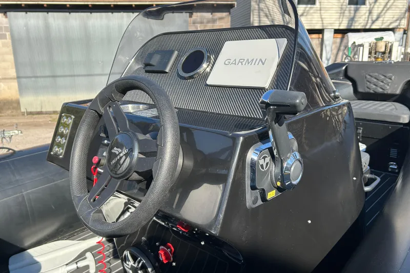 Slide: The Image of 2025 Highfield Sport 520 boat dashboard with Garmin navigation system and steering wheel. - 8