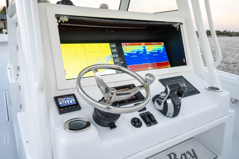 Slide: The Image of 2022 Onslow Bay 41 TE boat dashboard with navigation screens and steering wheel. - 12