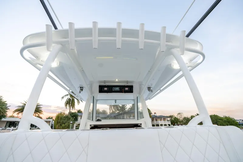 Slide: The Image of 2022 Onslow Bay 41 TE boat, white interior, view of helm and T-top, palm trees in background. - 15
