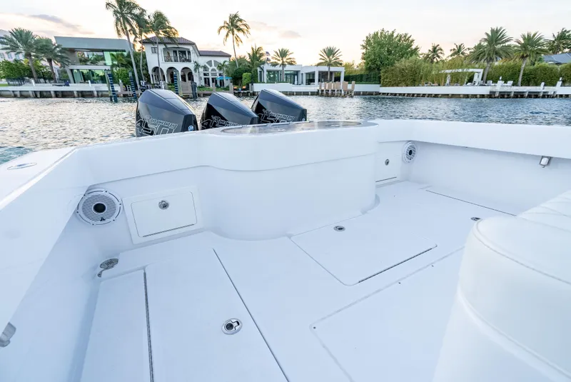 Slide: The Image of 2022 Onslow Bay 41 TE boat deck with triple engines, docked near waterfront homes. - 18