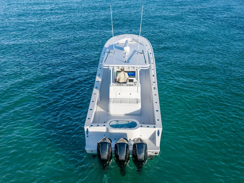 Slide: The Image of 2022 Onslow Bay 41 TE boat on clear blue water, rear view with triple engines. - 2