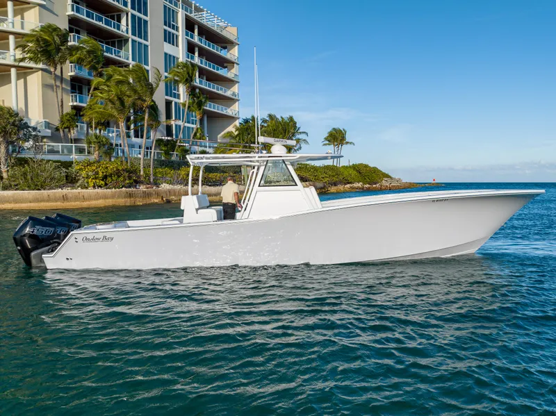 Slide: The Image of 2022 Onslow Bay 41 TE boat cruising near waterfront buildings and palm trees. - 22