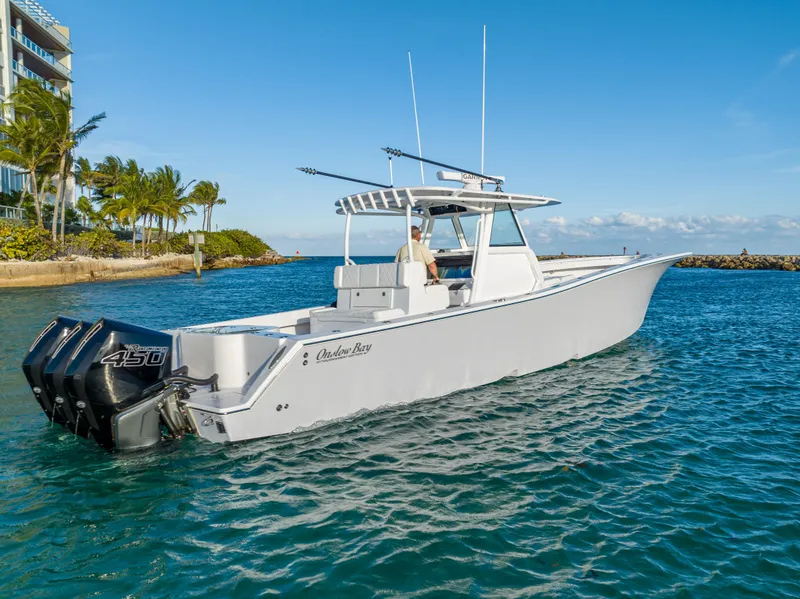 Slide: The Image of 2022 Onslow Bay 41 TE boat cruising in clear blue waters near a tropical shoreline. - 3