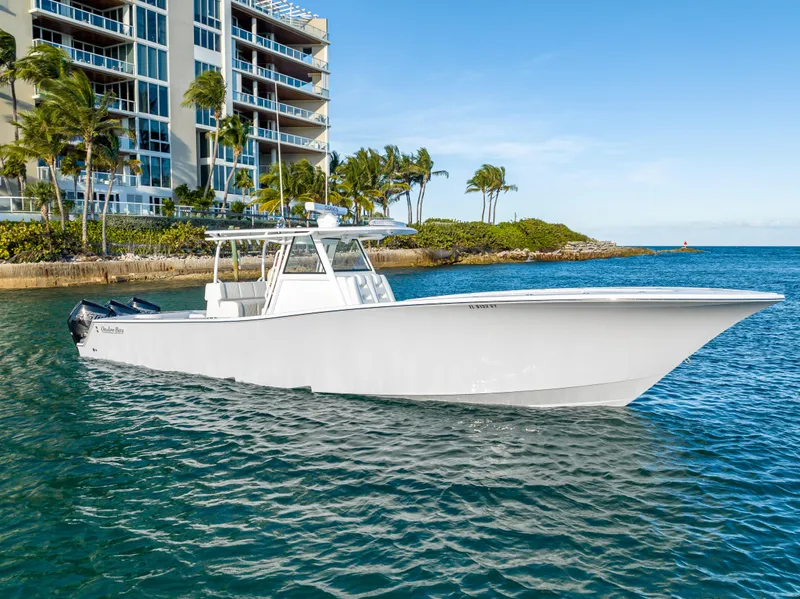 Slide: The Image of 2022 Onslow Bay 41 TE boat cruising near waterfront buildings and palm trees. - 4