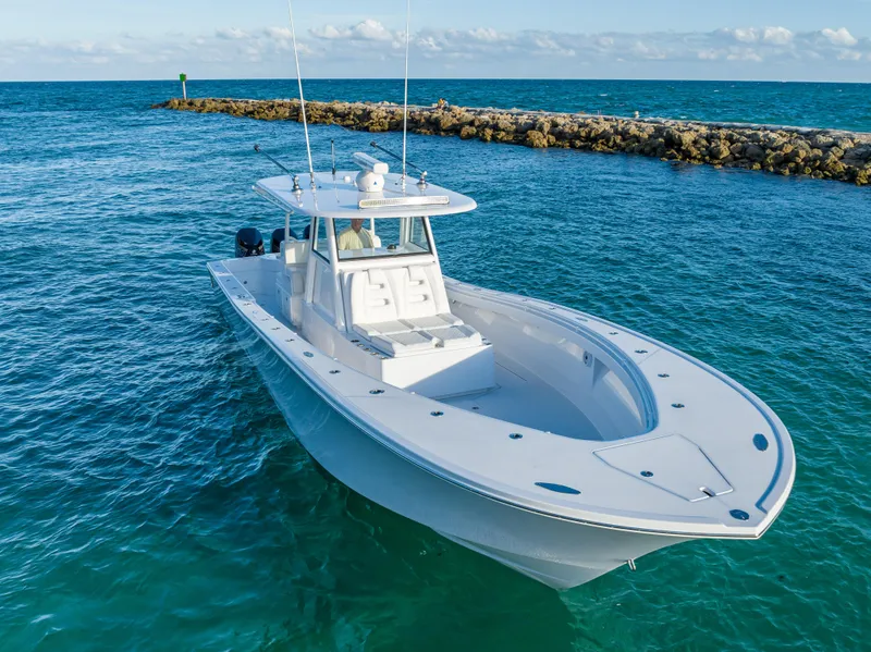 Slide: The Image of 2022 Onslow Bay 41 TE boat cruising on clear blue ocean near rocky shoreline. - 5