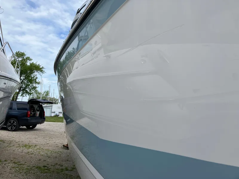 Slide: The Image of 2022 Aviara AV32 OB boat parked outdoors, side view with a car in the background. - 10