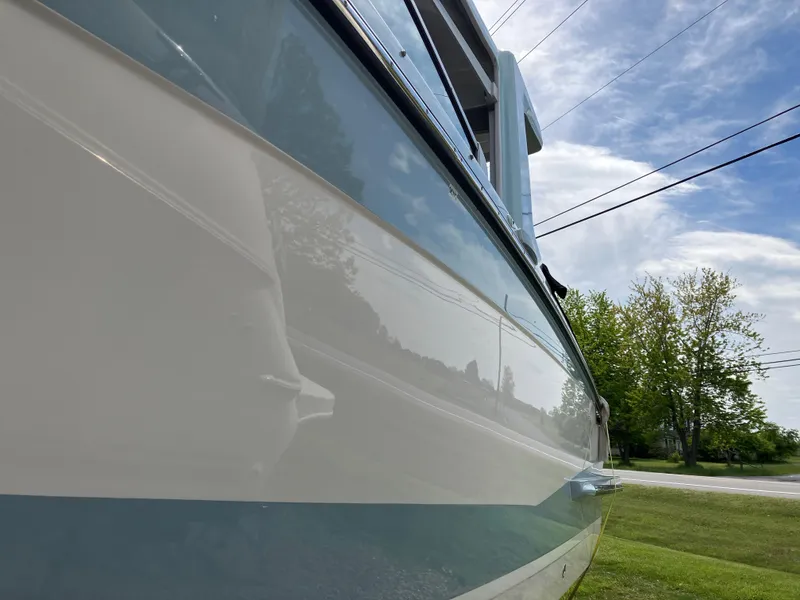 Slide: The Image of 2022 Aviara AV32 OB boat side view with clear sky and trees in background. - 14