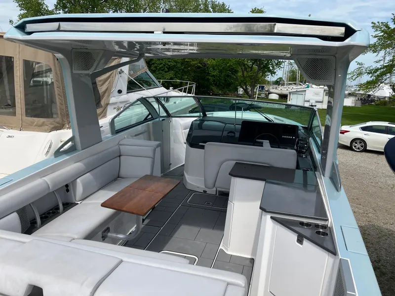 Slide: The Image of 2022 Aviara AV32 OB boat interior with sleek seating, modern helm, and wooden table. - 22