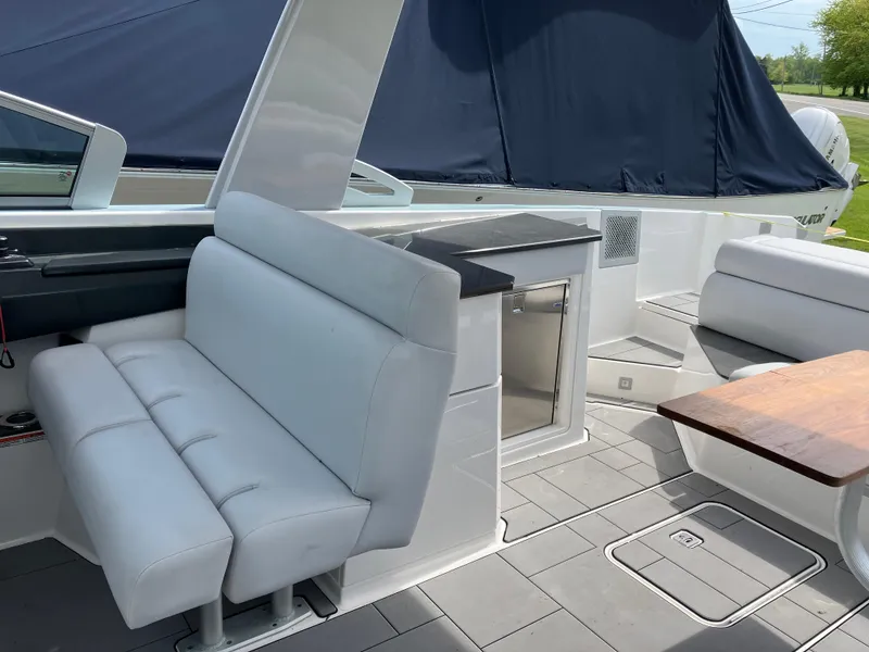 Slide: The Image of 2022 Aviara AV32 OB boat interior with white seating and a wooden table. - 32