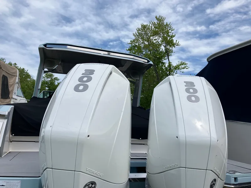 Slide: The Image of 2022 Aviara AV32 OB boat with twin 300 horsepower outboard engines, under a partly cloudy sky. - 8