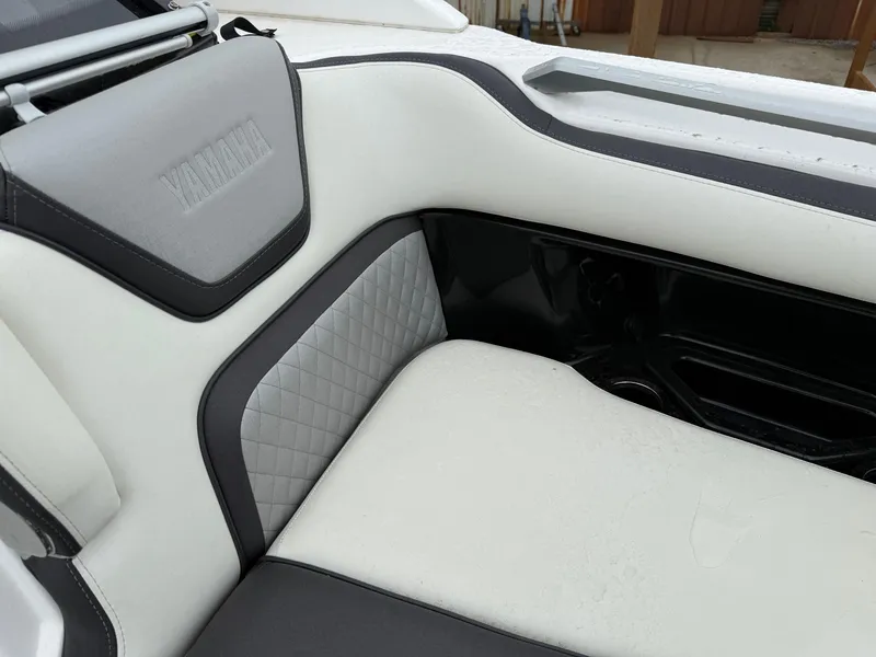 Slide: The Image of 2021 Yamaha Boats 275SE interior with white and gray cushioned seating. - 10