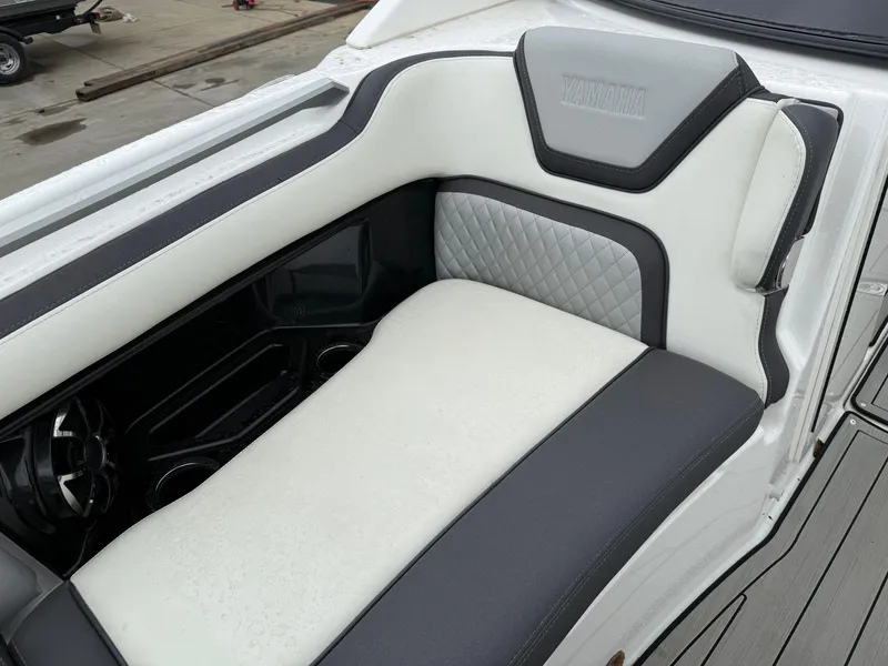 Slide: The Image of 2021 Yamaha Boats 275SE interior seating with white and gray upholstery. - 11