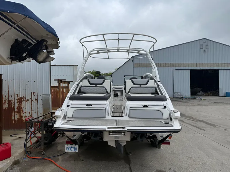 Slide: The Image of 2021 Yamaha Boats 275SE, white, docked near industrial buildings, overcast sky. - 9
