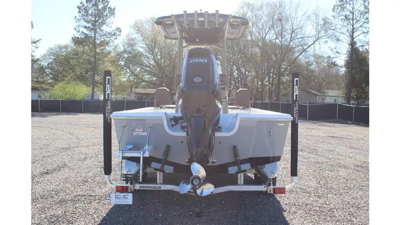 Slide: The Image of 2025 Sea Pro 230 Bay boat rear view with outboard motor in a gravel lot. - 5