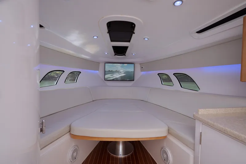 Slide: The Image of 2013 Intrepid 400 Cuddy interior with white seating, wood flooring, and ambient lighting. - 20