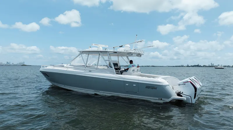 Slide: The Image of 2013 Intrepid 400 Cuddy boat on calm water under a partly cloudy sky. - 7