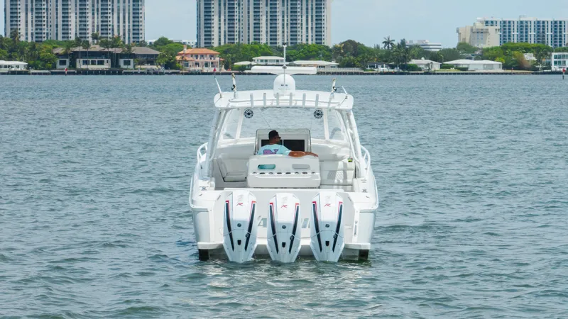 Slide: The Image of 2013 Intrepid 400 Cuddy boat with triple engines on water, cityscape background. - 9