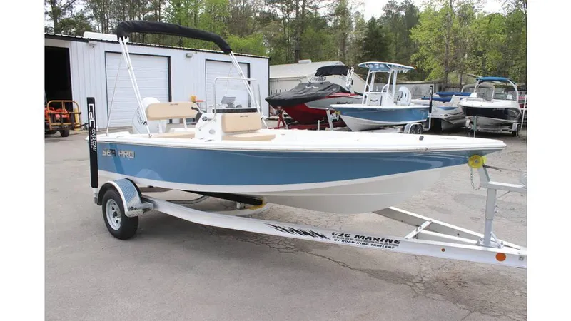 Slide: The Image of 2025 Sea Pro 172 boat on trailer, parked outdoors near other boats. - 2