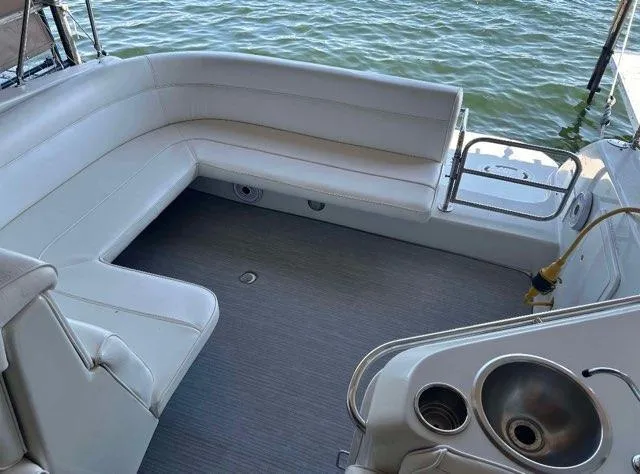 Slide: The Image of 1994 Chris-Craft 340 Crowne boat interior with white seating and sink, overlooking water. - 3
