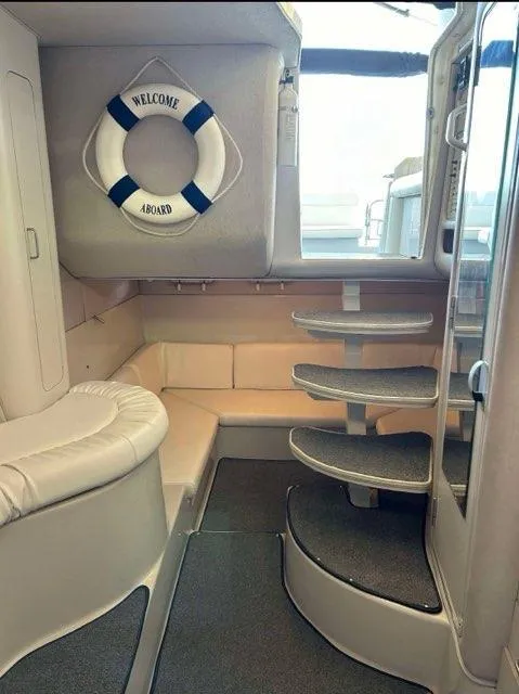 Slide: The Image of Interior of 1994 Chris-Craft 340 Crowne boat with seating and stairs, featuring a "Welcome Aboard" life ring. - 4