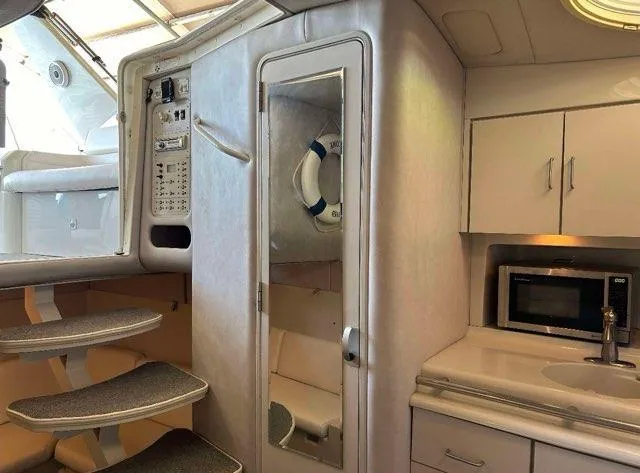 Slide: The Image of 1994 Chris-Craft 340 Crowne yacht interior with kitchenette, stairs, and mirrored door. - 8