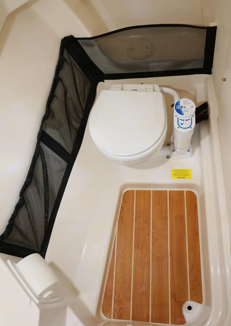 Slide: The Image of 2025 Grady-White Freedom 255 boat bathroom with toilet and wooden floor mat. - 9