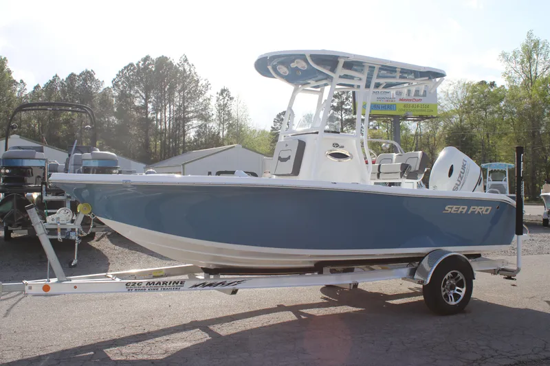 Slide: The Image of 2025 Sea Pro 202 CC boat on trailer, blue hull, parked outdoors. - 2