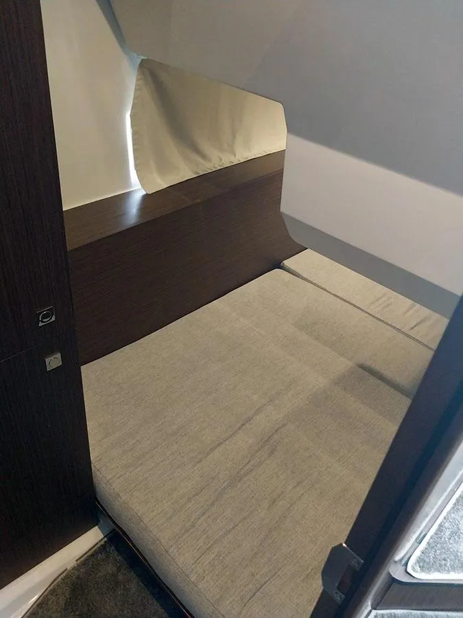 Slide: The Image of 2023 Jeanneau NC 1095 Fly cabin interior with a cozy bed and modern design. - 12