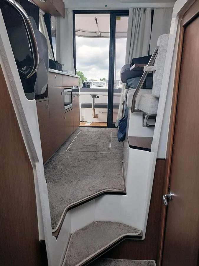 Slide: The Image of Interior view of 2023 Jeanneau NC 1095 Fly yacht, featuring modern design and carpeted stairs. - 13