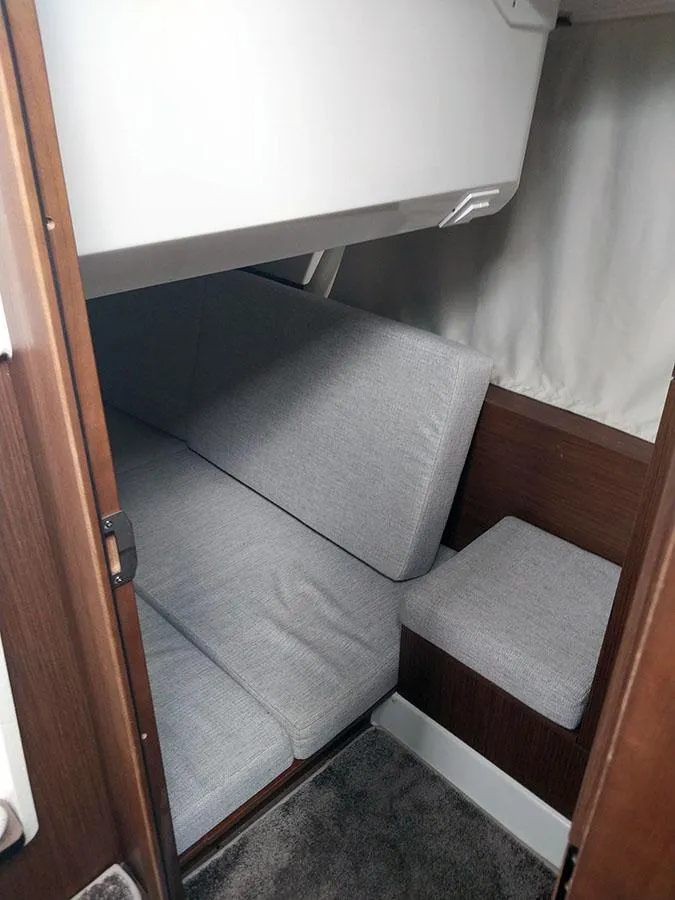 Slide: The Image of 2023 Jeanneau NC 1095 Fly cabin interior with gray seating and wooden accents. - 14