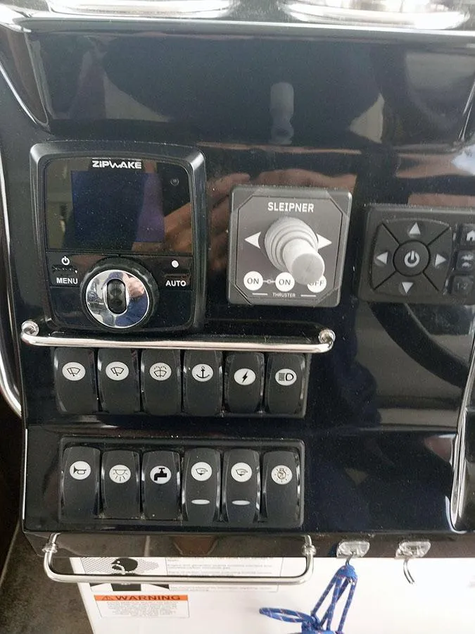 Slide: The Image of Control panel of 2023 Jeanneau NC 1095 Fly boat with various switches and dials. - 16