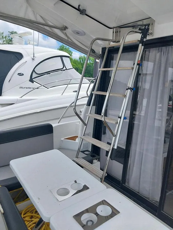 Slide: The Image of 2023 Jeanneau NC 1095 Fly yacht with ladder and outdoor seating area. - 22