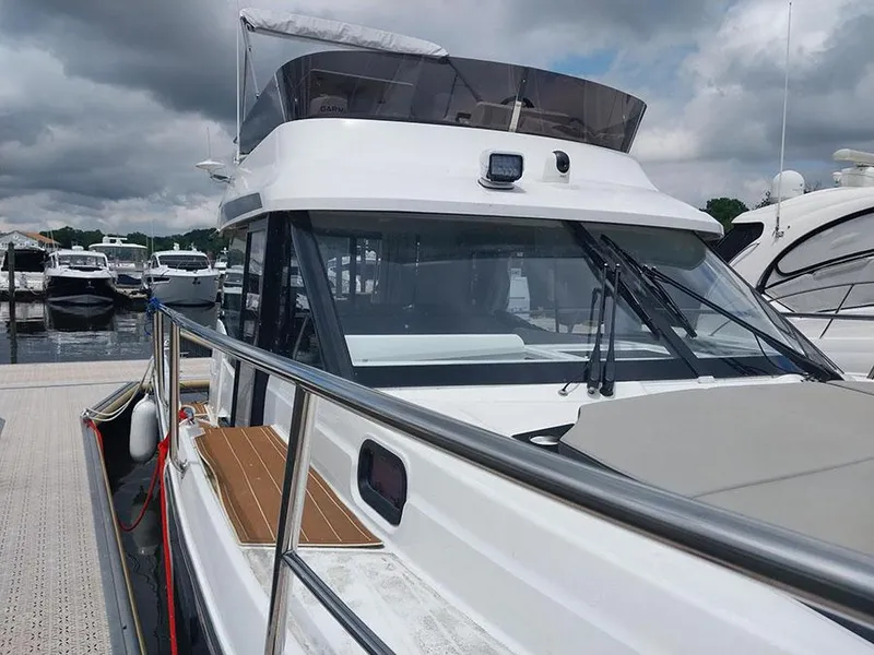 Slide: The Image of 2023 Jeanneau NC 1095 Fly yacht docked at marina under cloudy sky. - 4