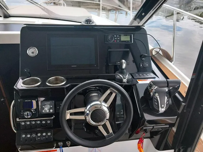 Slide: The Image of 2023 Jeanneau NC 1095 Fly helm with steering wheel, controls, and navigation display. - 5