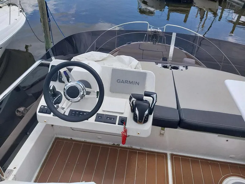 Slide: The Image of 2023 Jeanneau NC 1095 Fly helm with Garmin navigation, docked on calm water. - 6