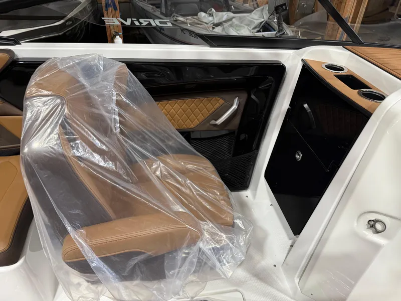 Slide: The Image of 2025 Yamaha Boats 252SD interior with brown seating, plastic cover, and cup holders. - 4