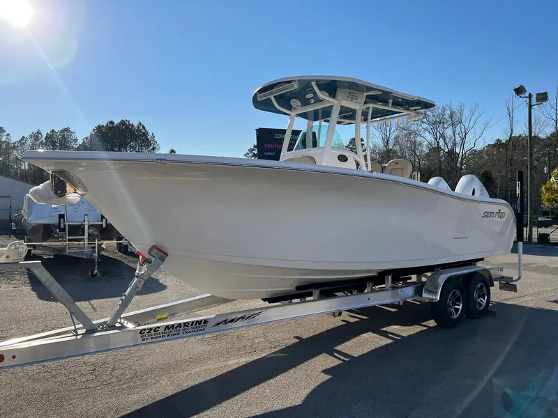 Slide: The Image of 2022 Sea Pro 259 Deep V Series CC boat on trailer under clear blue sky. - 1
