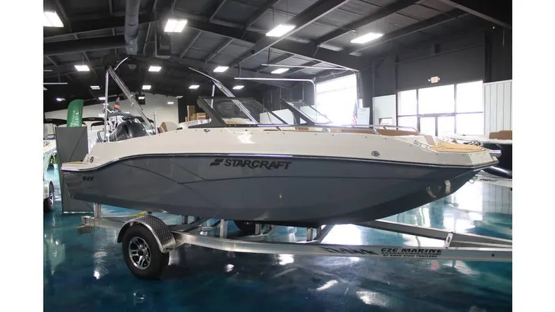 Slide: The Image of 2025 Starcraft SVX 190 OB DC boat displayed indoors on a trailer. - 10