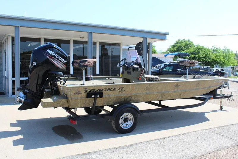 Slide: The Image of 2018 Tracker GRIZZLY® 1860 CC boat with Mercury engine, parked outside a building. - 12