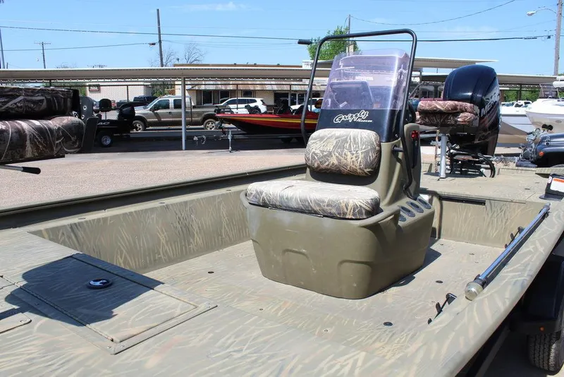 Slide: The Image of 2018 Tracker GRIZZLY® 1860 CC boat with camouflage seating, parked outdoors. - 4