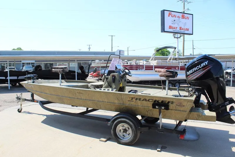 Slide: The Image of 2018 Tracker GRIZZLY® 1860 CC boat on trailer at dealership, featuring Mercury outboard motor. - 9