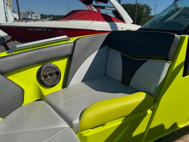 Slide: The Image of 2018 MasterCraft XT22 boat interior with vibrant yellow and gray seating, featuring a built-in speaker. - 10