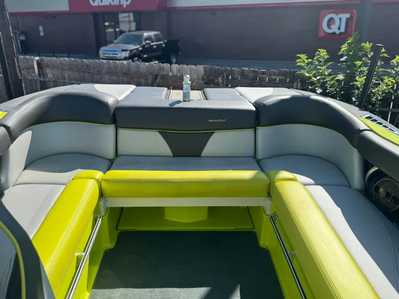 Slide: The Image of 2018 MasterCraft XT22 boat interior with lime green and gray seating. - 16