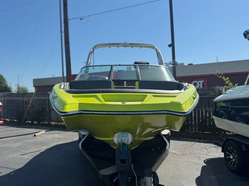 Slide: The Image of 2018 MasterCraft XT22 boat in bright green, parked outdoors on a trailer. - 3